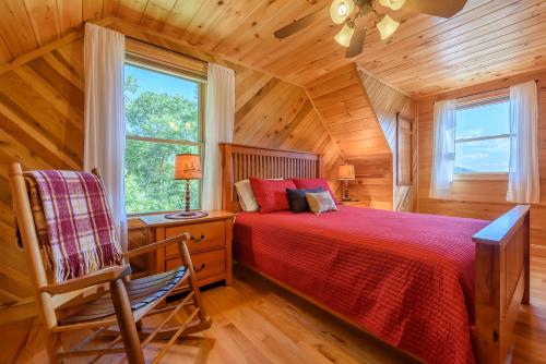 een slaapkamer met een bed en een stoel in een kamer bij Elk Knob Cabin in Boone