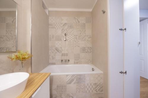 La salle de bains blanche est pourvue d'une baignoire et d'un lavabo. dans l'établissement Charm and Style by Campo de Fiori, à Rome
