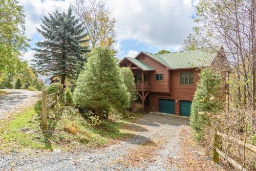 a wooden house with a fence and a driveway at Fox Crossing in Banner Elk