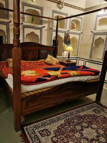 a bedroom with a wooden bed with a rug and a mirror at Hotel Radhika Haveli, Mandawa in Mandāwa