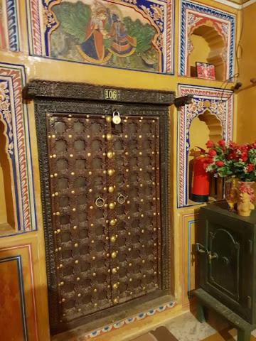 a wall with a large door in a room at Hotel Radhika Haveli, Mandawa in Mandāwa