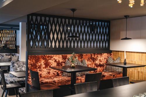 a restaurant with tables and chairs and a wall at ARPURIA l 4 Star Superior l Adults Only in Sankt Anton am Arlberg