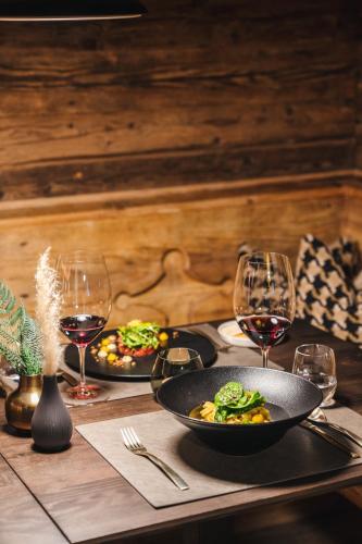 a table with two plates of food and wine glasses at ARPURIA l 4 Star Superior l Adults Only in Sankt Anton am Arlberg