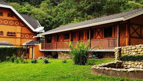 a large house with a green yard in front of it at Pousada Casa dos Sonhos in Campos do Jordão