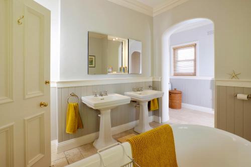 uma casa de banho branca com 2 lavatórios e um espelho em Yoku House em Bournemouth