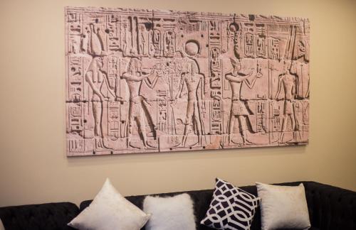 a painting hanging on a wall above a couch at Asia Grand Museum & Pyramids view in Cairo