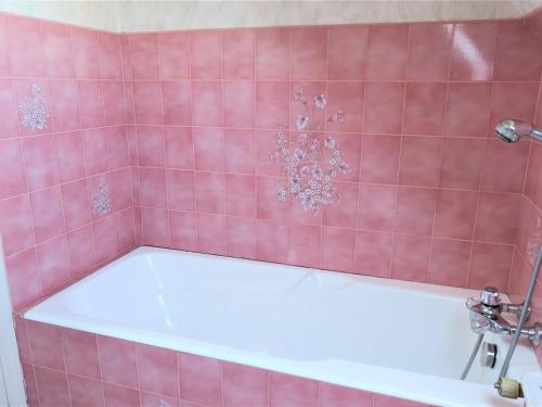 - une salle de bains carrelée de rose pourvue d'une baignoire dans l'établissement Maison conviviale avec jardin, WIFI gratuit, à 900m de la plage de Trestraou, Perros-Guirec - FR-1-368-291, à Perros-Guirec