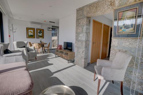 - un salon avec un canapé, des chaises et une télévision dans l'établissement Casas de Tourim, à Arcos de Valdevez