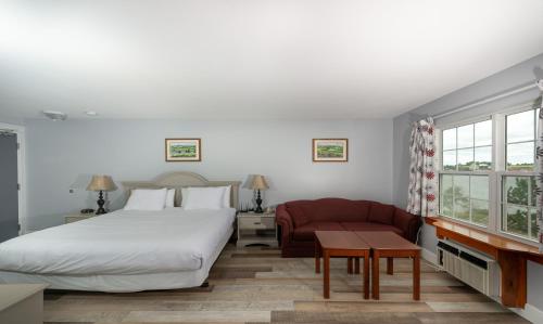 ein Schlafzimmer mit einem großen Bett und einem roten Sofa in der Unterkunft Inn at the Pier in Cavendish