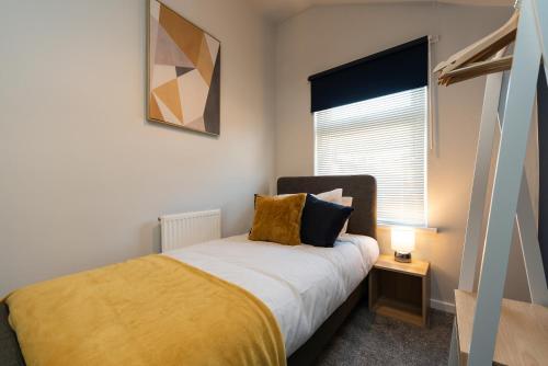 a bedroom with a bed with a yellow blanket and a window at Chic 3BR House in Hull - sleeps 5 in Hull