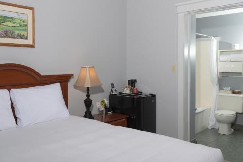 ein Schlafzimmer mit einem Bett und ein Badezimmer mit einem WC in der Unterkunft Inn at the Pier in Cavendish