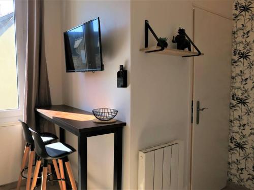 une pièce avec une table, une télévision et une porte dans l'établissement Studio rénové avec WIFI, à 400m de la plage, centre de Trégastel - FR-1-368-299, à Trégastel