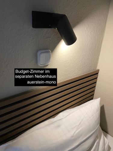a sign on the wall above a bed with a headboard at AUERSTEIN-Hotels auerstein & auerstein-mono in Heidelberg