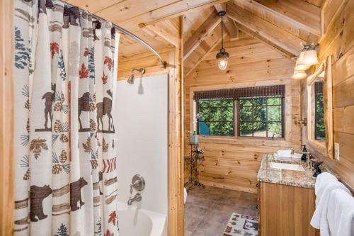 Lake Haven Lodge في ويلكسبورو: حمام مع حوض استحمام وستارة دش