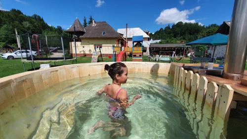 Une petite fille dans un bassin d'eau dans l'établissement Casa Petruta Dambovicioara, à Podu Dîmboviţei