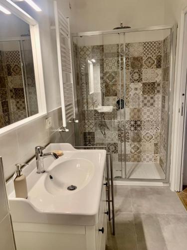 uma casa de banho branca com um lavatório e um chuveiro em La casa di Carolina em Florença