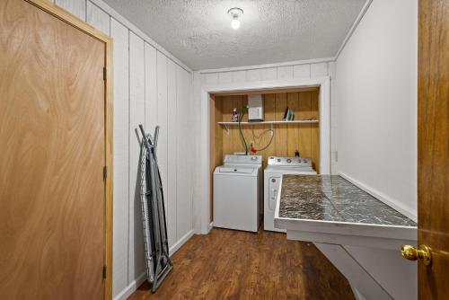 a small kitchen with a stove and a washer and dryer at Longview Lodge in Boone