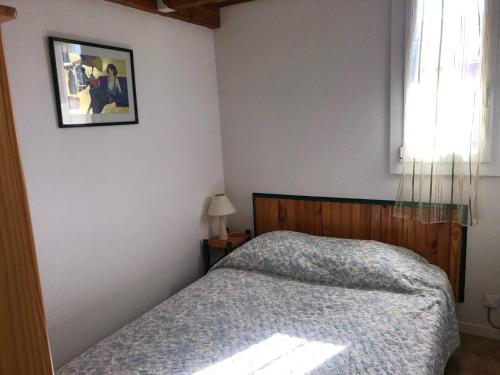 une chambre avec un lit et un tableau au mur dans l'établissement Appartement T4 climatisé, 6 couchages, balcon, proche commerces et plage, parking, situé à Port Leucate - FR-1-81-544, à Leucate