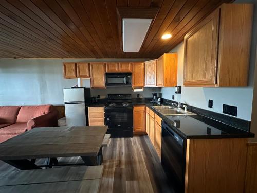 a kitchen with wooden cabinets and black appliances and a table at Canyon Lakeview Resort in Canyon Lake