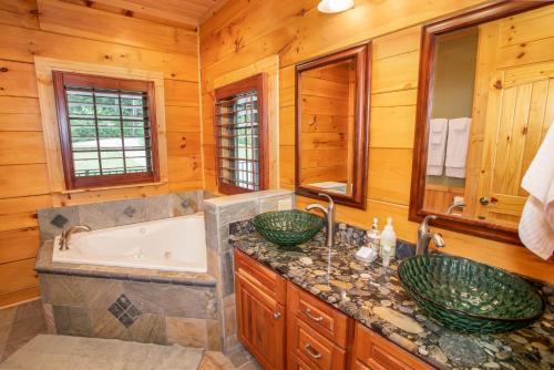 La salle de bains est pourvue de 2 lavabos, d'une baignoire et d'une chambre. dans l'établissement Malone Bay On Kerr Scott Lake, à Wilkesboro