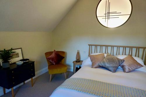 1 dormitorio con 1 cama, 1 silla y 1 lámpara de araña en Yoku House, en Bournemouth