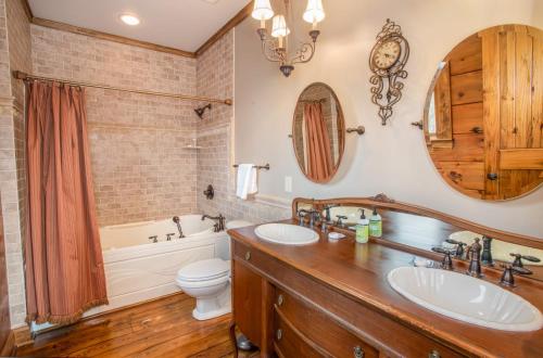 a bathroom with two sinks and a tub and a toilet at Mountain Laurel Lodge in Blowing Rock