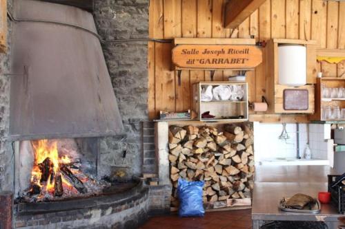 d'une cheminée avec un tas de bois de chauffage. dans l'établissement Le cocon Pèlerins, aux Angles
