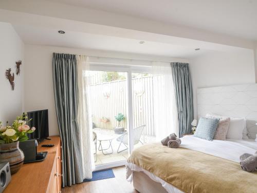 a bedroom with a large bed and a balcony at Blue Neptune in Lyme Regis