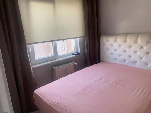 una camera con letto rosa e finestra di Eviniz gibi Hijyenik Rahat Edebileceğiniz Daire a Istanbul