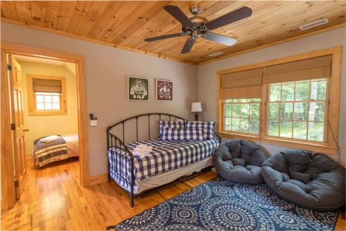 a bedroom with a bed and two chairs and a ceiling fan at Mountain Melody in Blowing Rock
