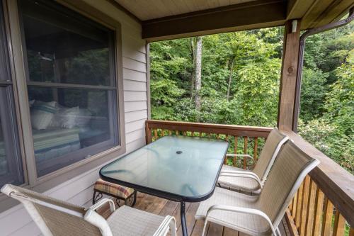 a screened in porch with two chairs and a table at Mountain Melody in Blowing Rock