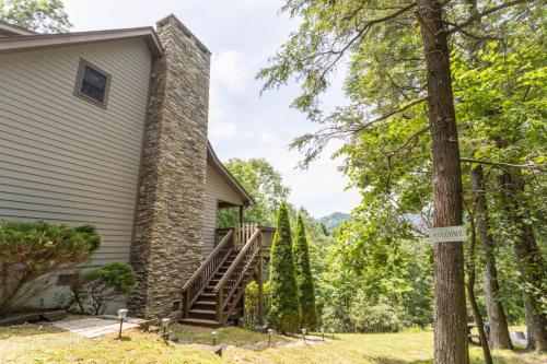 a house with a stone chimney and a staircase at Mountain Melody in Blowing Rock