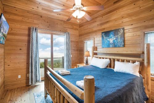 una camera da letto con un letto e un ventilatore a soffitto di Mountain Top Lodge a Beech Mountain
