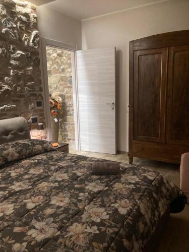 a bedroom with a large bed and a stone wall at Cascina Manzo in Dogliani