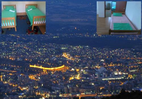 two beds in a room with a city at night at BSV Hostel in Skopje