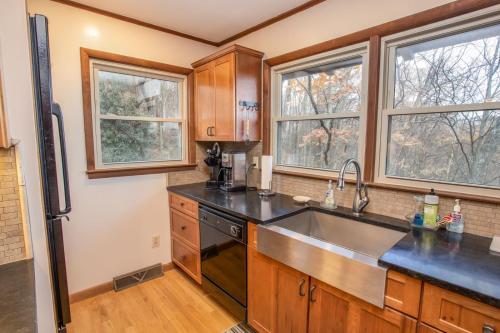 a kitchen with a sink and two windows at Out On A Limb in Blowing Rock