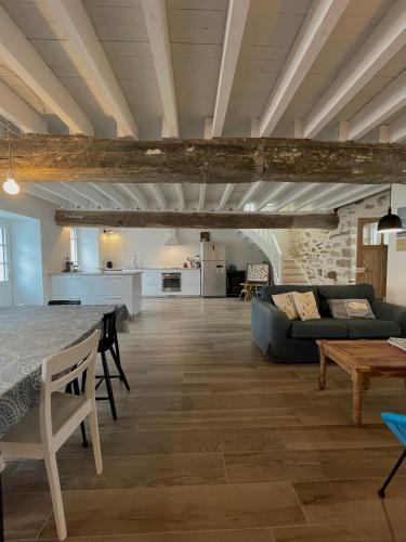 een woonkamer met een bank en een tafel bij Maison bord de mer ・La côtière・ in Piriac-sur-Mer