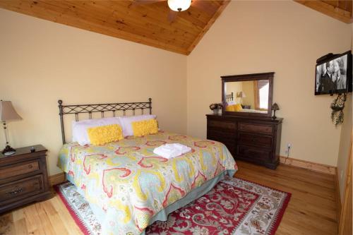 a bedroom with a bed with a mirror and a rug at Ridgeline Cabin in Elk Park