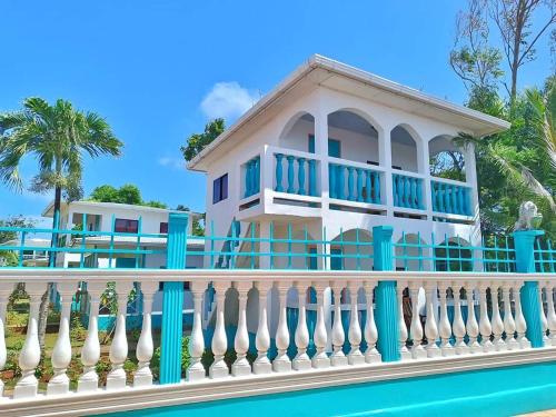 une maison avec une clôture blanche et une piscine dans l'établissement Los Delfines Hotel & Dive Center, à Little Corn Island