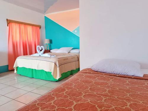 a bedroom with a bed and a blue and red wall at Los Delfines Hotel & Dive Center in Little Corn Island