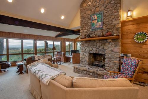 a living room with a stone fireplace and a couch at Serendipity in Blowing Rock