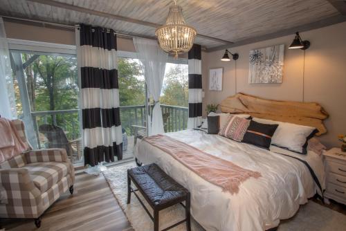 a bedroom with a bed and a chair and a window at Skyleaf on Sugar in Sugar Mountain