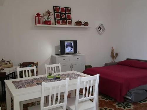 - une chambre avec une table, un lit et une télévision dans l'établissement Signora Minù Bilocale Semindipendente, à Lecce
