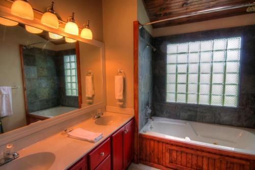 Un baño con bañera, lavabo y espejo. en Sleepy Hollow, en Boone