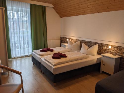a hotel room with two beds with red towels on them at Pension Auf der Tenne in Klöden