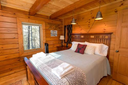 - une chambre avec un lit dans une cabane en rondins dans l'établissement Stoney Brook Cabin, à Boone
