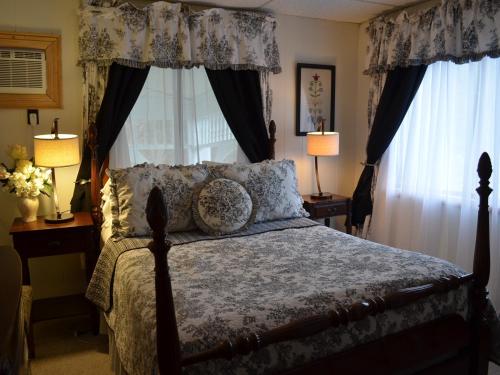um quarto com uma cama e duas janelas com cortinas em The Bavarian Manor Hotel em Purling