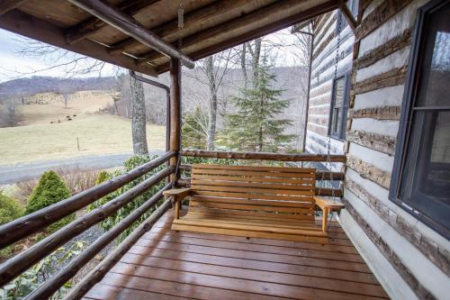 a wooden bench sitting on the front porch of a house at Speckles in Todd