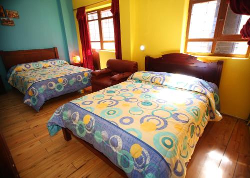 1 dormitorio con 2 camas, sofá y 2 ventanas en Hostal Bavaria de la Alameda, en Quito