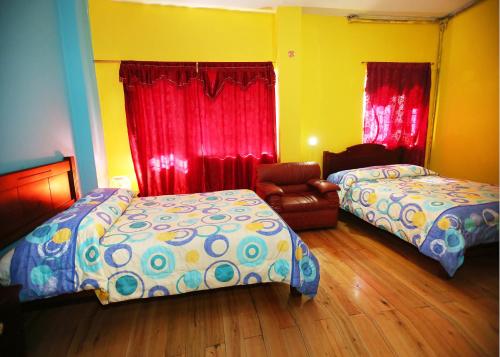 1 dormitorio con 2 camas y 1 silla en Hostal Bavaria de la Alameda, en Quito